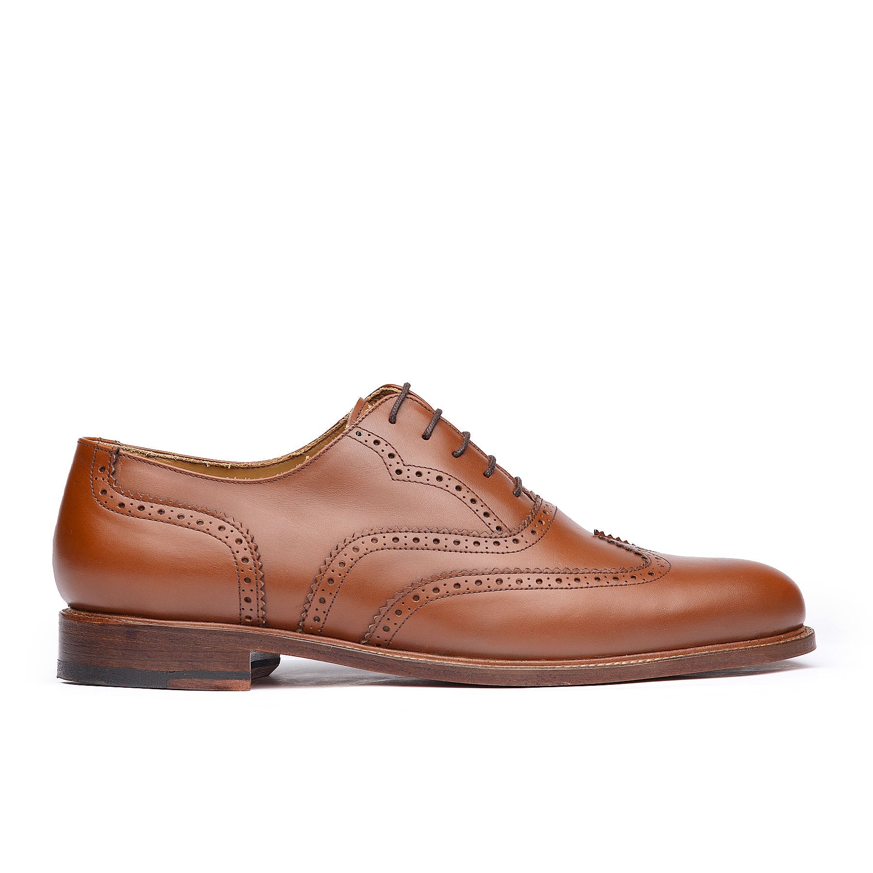 Tan wingtip shoes with brogues on leather upper and closed eyelet for formal wear